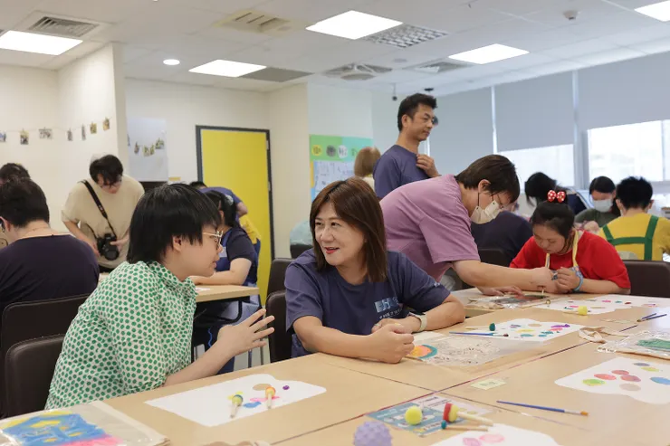 ▲直銷協會理事長蔡孟紅，現場與憨兒交流，聊談彼此興趣愛好。（圖/直銷協會提供）