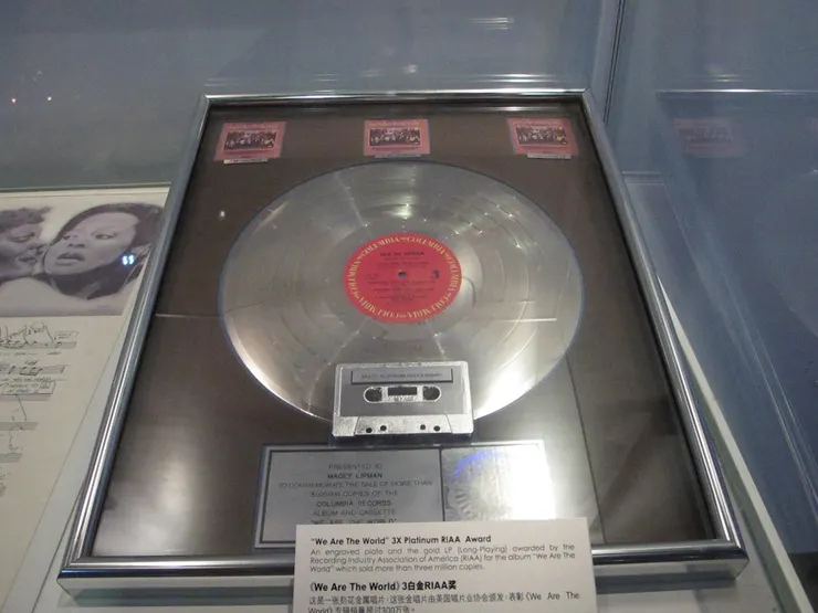 這是《We are the World》所得到的獎。根據下面的小字卡描述,這是一張刻花的金屬唱片,表彰此專輯賣出超過300萬張。我還是第一次看到金屬的唱片!