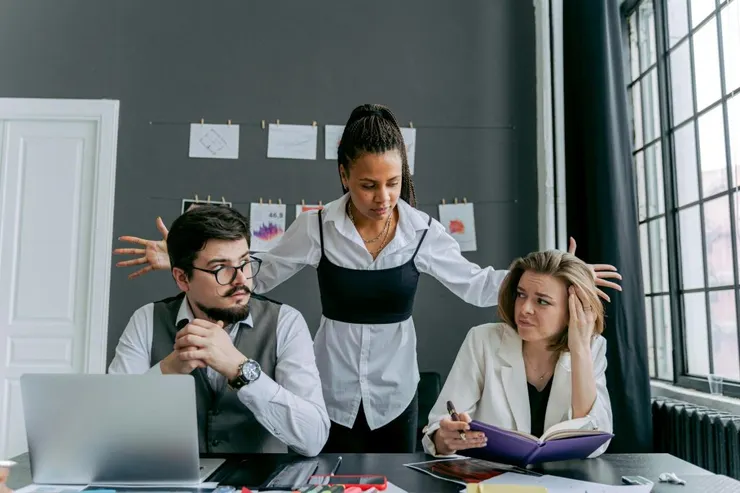 employees in an office and gray wall in background