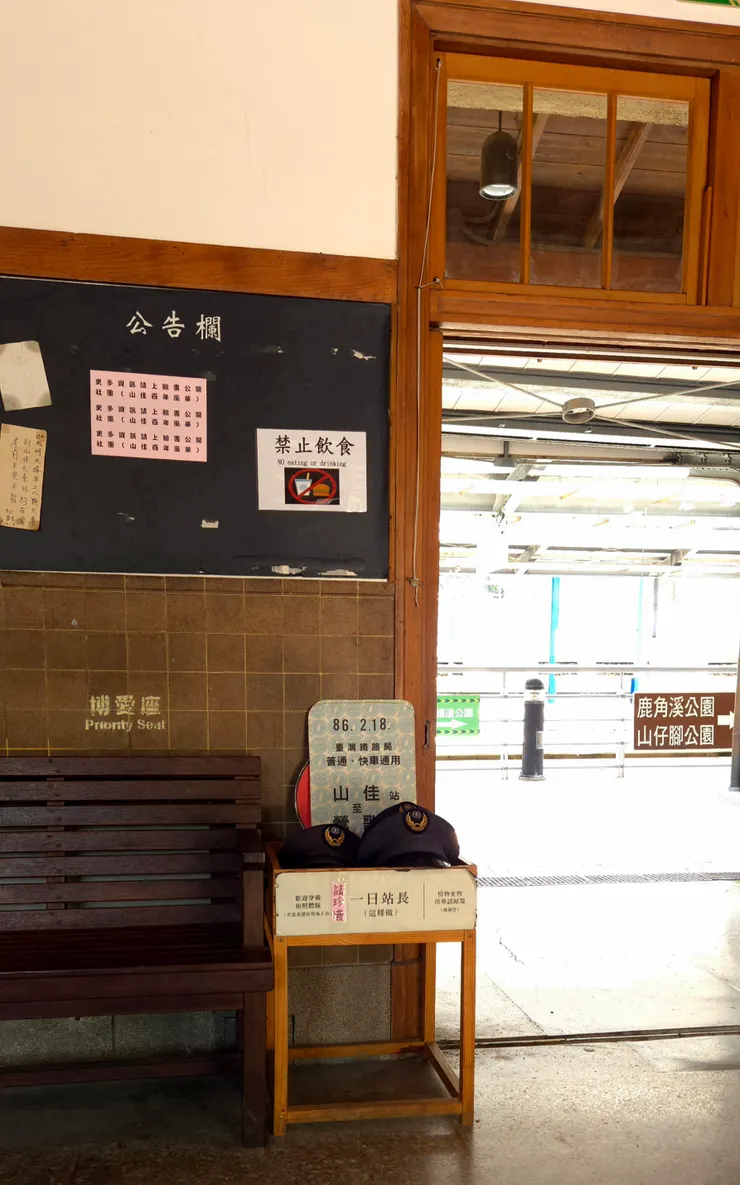 公告欄上貼滿了各種資訊,失物招領、禁止飲食標示、活動傳單,展現出社區的溫情和生活的百態。深色木椅供人休息,幾頂站長警帽和「一日站長」的標誌,讓參訪者思考責任和體驗人生。