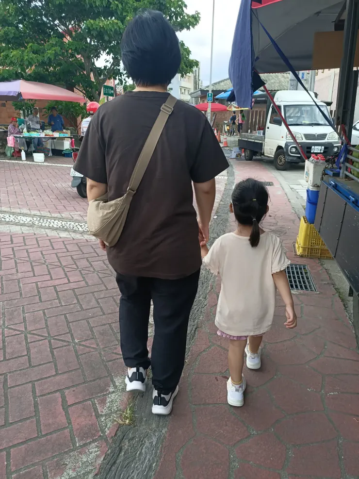 小妹很開心要去套圈圈，跟阿姨手牽手