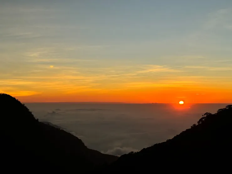 血紅色的太陽沉在遠方的雲海上如夢似幻