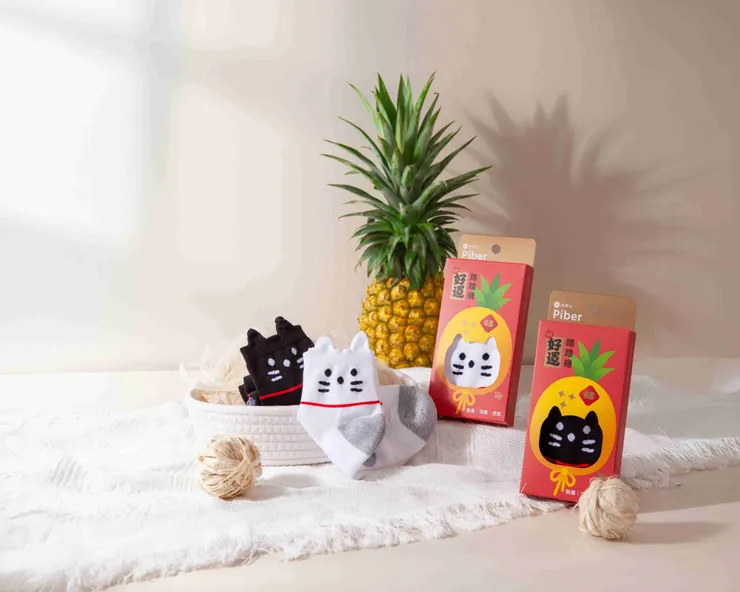 圖說：堅持全果應用永續理念，最新上架的「好運踏踏襪」，每雙使用6片以上鳳梨葉子、採用高達4%鳳梨葉纖維製成，用超萌旺萊貓圖案全面搶攻你的日常生活，讓時尚也能很永續！（資料來源：旺萊山）