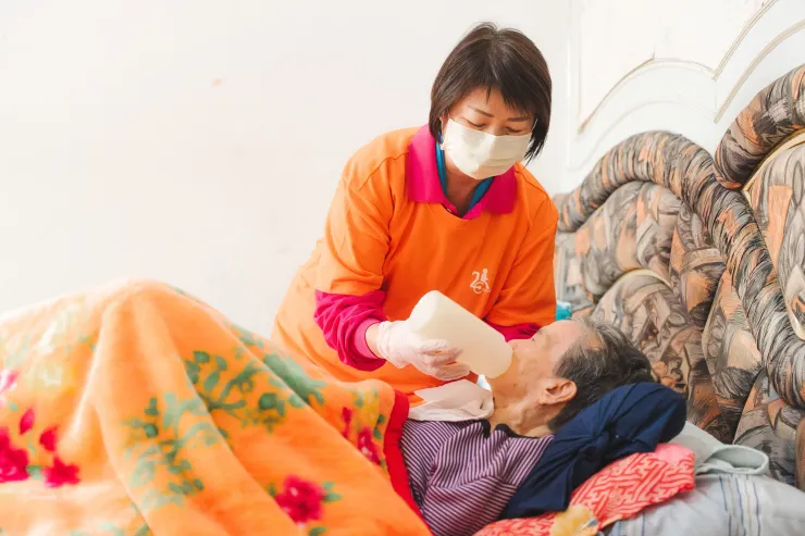 吳美瑢協助臥床長輩進食。