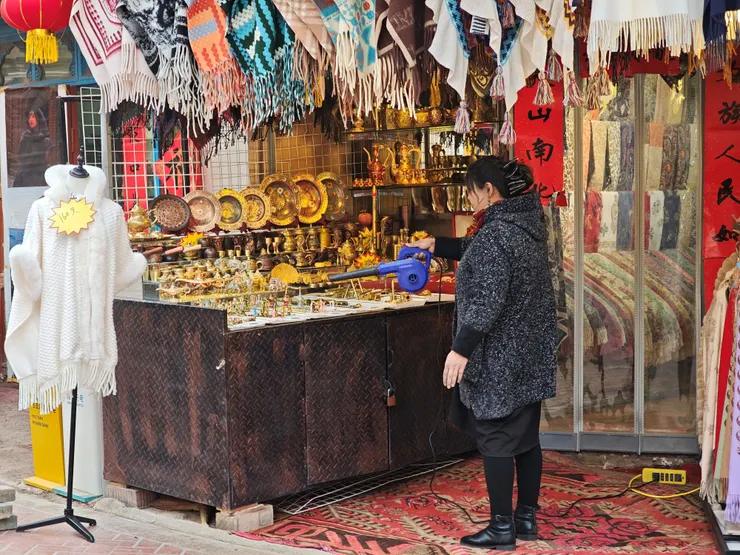 店家直接用中型落葉吹風機清除抬面上的沙塵