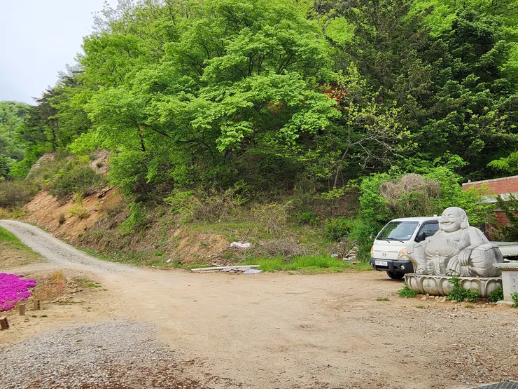 登山入口指示牌旁邊有一座可愛的彌勒佛坐像