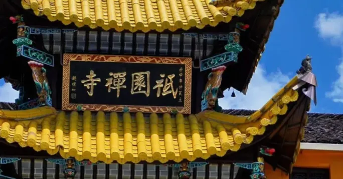 祇園寺的屋頂上,金色的瓦片和雕刻精美的屋脊與藍天相映成趣,匾額上寫著「禪禪國祀」字樣