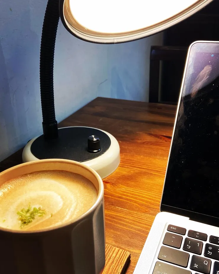 昏黃的燈光配上電腦與奶茶
