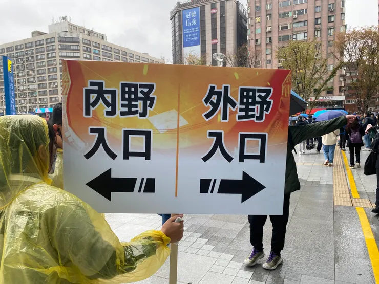 工作人員舉牌指引內外野方向