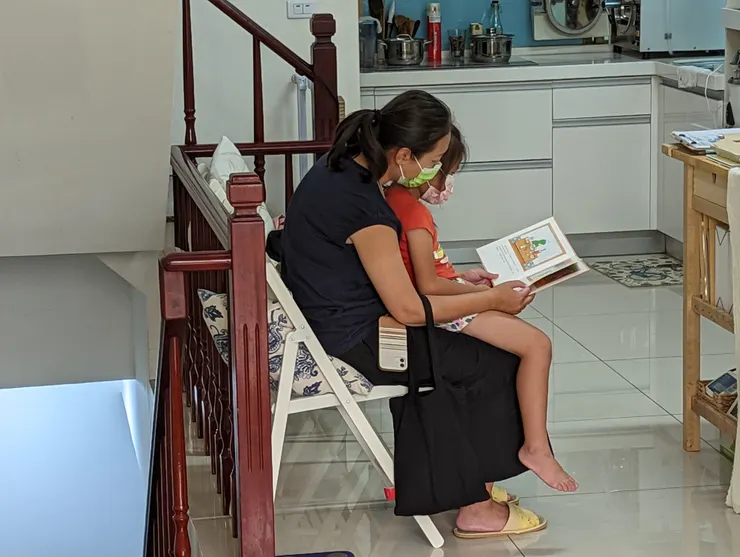 這張圖是我很喜歡的一張圖,拍攝於我目前的診所,候診區,媽媽很自然的抱著小孩『讀』書