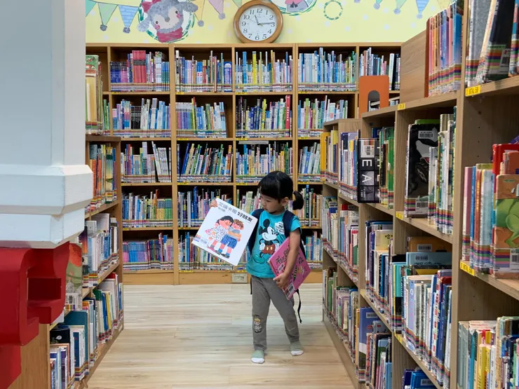 在圖書館選書的禾(2歲10月)