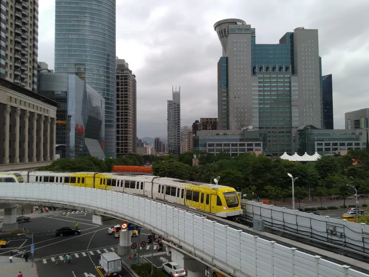 圖示：新北捷運公司接手前，由台北捷運經營時期的環狀線列車通過板橋站附近，旁邊是新北市政府大樓。圖片來源為張居隱：https://www.shutterstock.com/zh-Hant/image-photo/2419289035