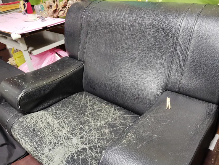 這張乘載著人來人往倚坐與磨蹭的塑皮沙發,終於留下了一條條沒法抹除的刻痕了