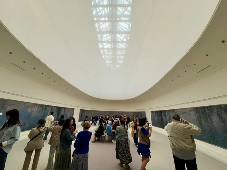 這張特地將屋頂照進來，能看到天然的採光是怎麼做到的。右前方穿藍色襯衫的V正坐著看畫。