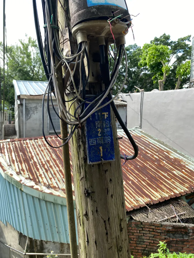 古老的木樁電線桿，上面牌子標示著老地名「下內埔」（拍攝日期：2025/7）