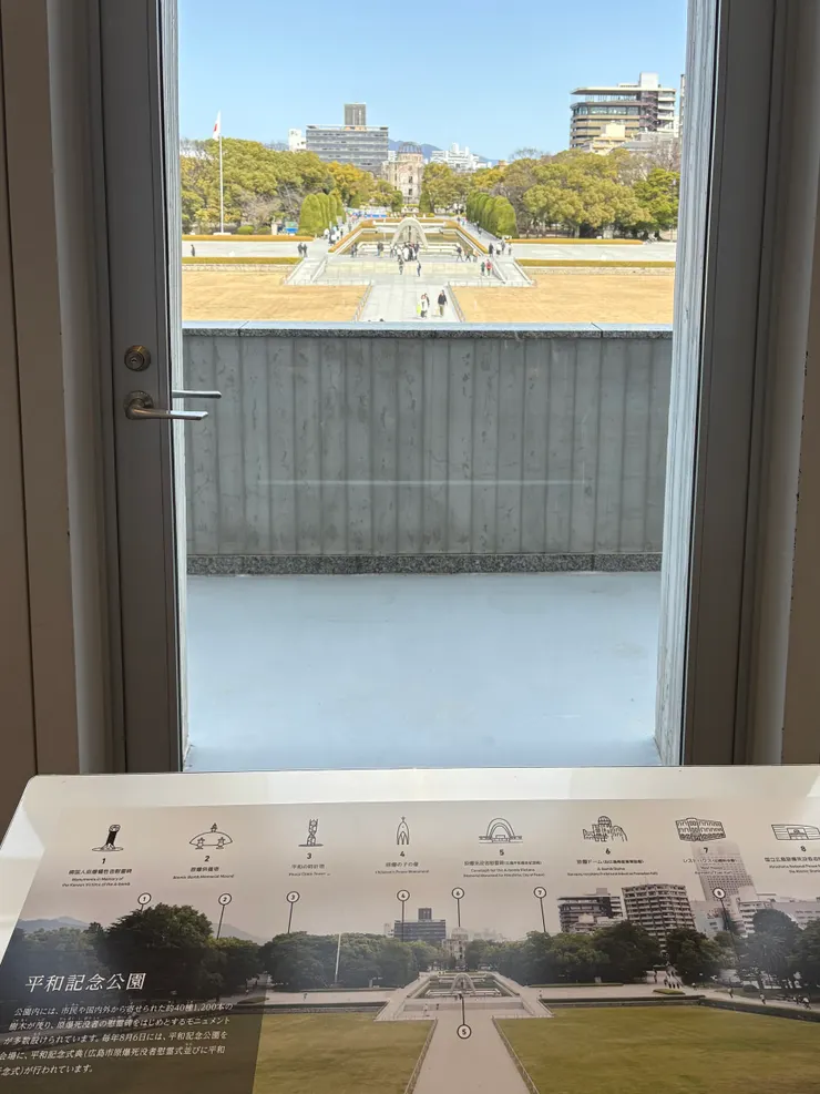 從長廊的窗櫺向外觀看，可以看的紀念碑與原爆圓頂連成一線。