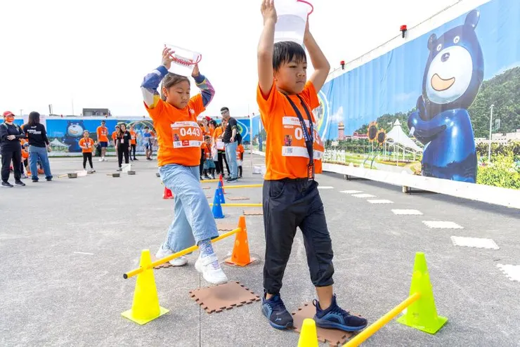 ▲路跑現場「取水挑戰」體驗活動，參賽小朋友模擬跨越路障、頭頂水桶，體驗取水的不易。（台灣世界展望會提供）