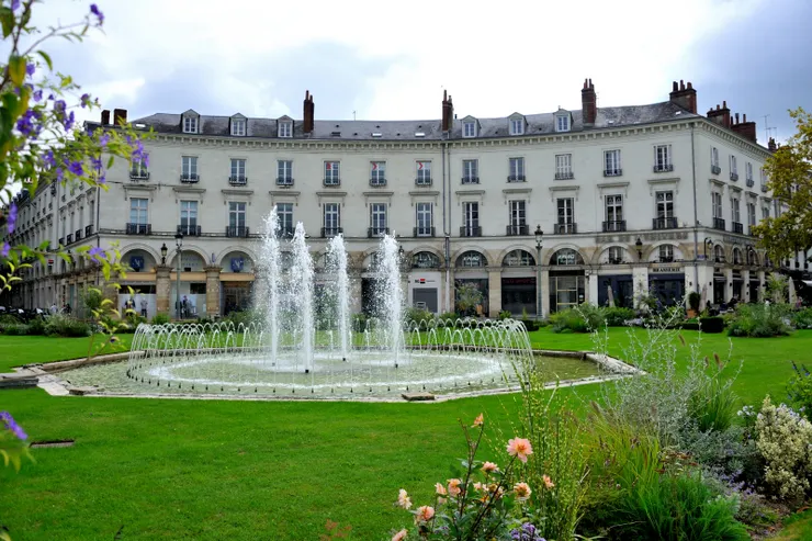 【市政廳對面的噴泉綠地及商家，隔著國民街與另一邊形成對稱。】