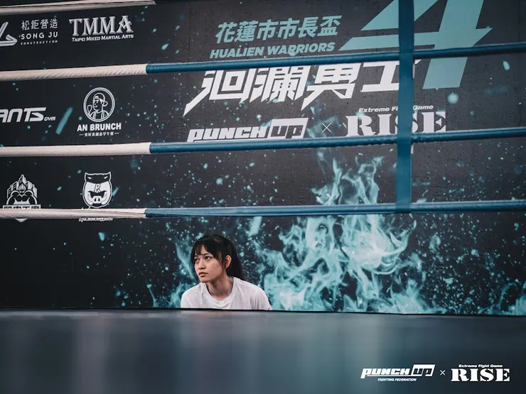 註1:圖為洄瀾勇士格鬥賽的擂台，圖內人物為本次執裁的裁判之一王靖蓉教練，圖片引用自Punch Up格鬥聯盟粉專。