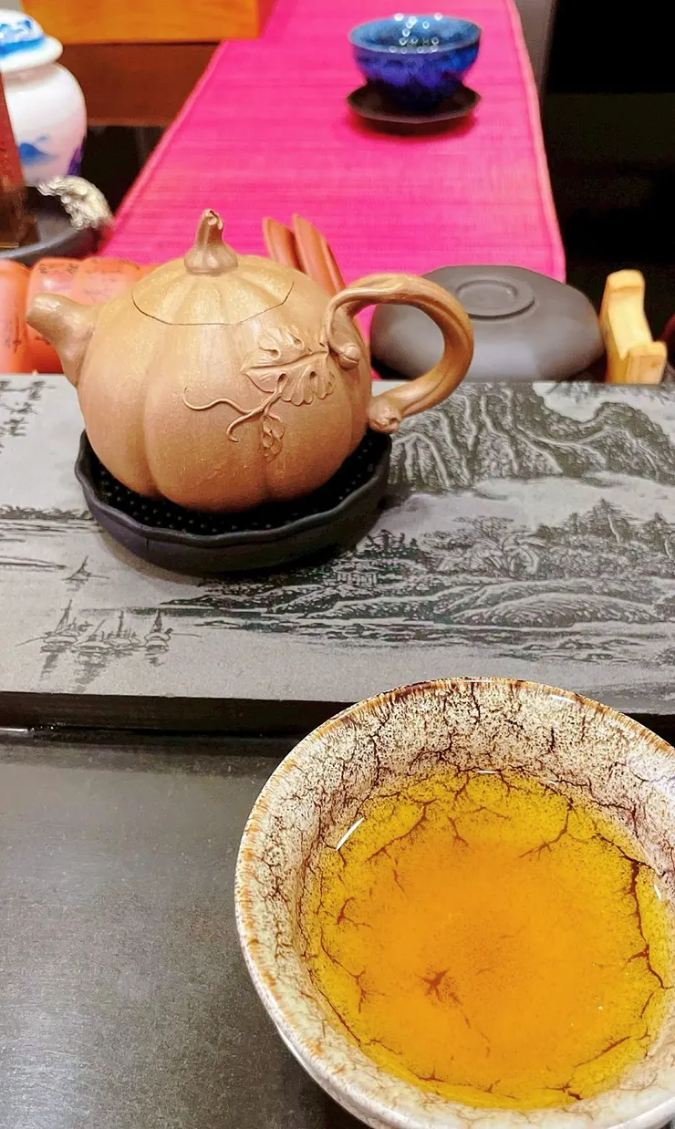 泡了一杯茶給他。照片裡，他的杯子在最遠的那頭。