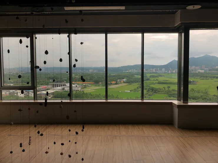 【圖1】楊季涓作品《下雨了》與窗外關渡平原。攝影|作者