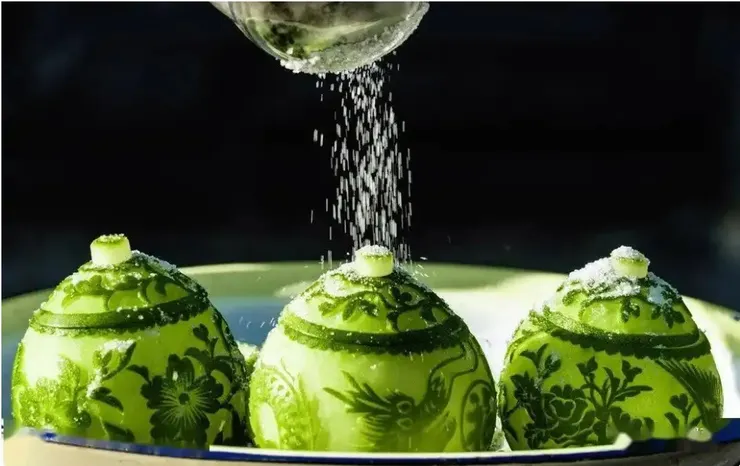 雕好的水果在用白糖醃製。靖州雕花蜜餞被認為起源於五代，是宋代蜜煎藝術的民間分支，更是該項技藝流傳至今的「活化石」。