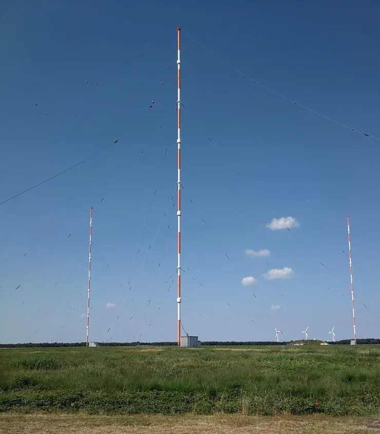 由於電磁訊號會因為海水而迅速衰減，而潛艦上浮時哪怕只是接收訊息也相當容易被雷達發現，因此和潛艦通聯有相當大的難度。但二戰前科學家注意到長波訊號衰減無論在空中還是水中都更小，因此只要波長夠長且訊號夠強，就可能抵銷衰減從而實現通訊。為此二戰期間德國建立了名為哥利亞的VLF波段通訊設備，能夠將資訊傳送給遠距離外且仍在水下的潛艦；這一技術在二戰後繼續得到發展，最終有了天線尺寸長達數十公里的ELF通訊設施。但這些水下通聯是單向的，因為潛艦無法容納長波通訊所需的天線尺寸以及功率。圖為1982年起運行的德國DHO38發射站，該站使用8根353公尺高的天線塔佈置傘型的VLF天線，可和水下30米的潛艦傳遞訊息。