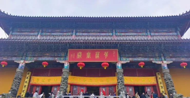 旃檀林的正面，紅色匾額上寫著「開光大吉」，黃色的大門口掛著紅燈籠，旁邊的雕像與細緻的建築細節令人印象深刻。