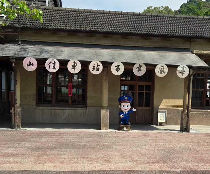 一只穿著小警服的小站長公仔站在舊山佳車站的門口,這是一座傳統泥、磚、木、黑瓦構造的古老房子。時間在這裡好像慢了下來。屋簷掛著「山佳車站百年風華」的看版,靜靜地守護著過去。 「我們去看看以前的火車票亭長什麼樣子吧!」
