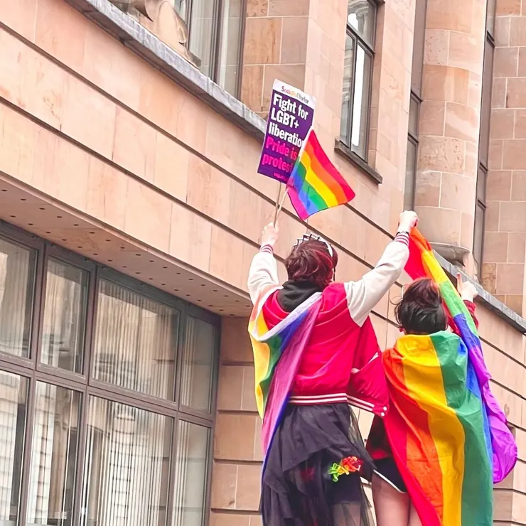 遊行時的人們在身上披戴彩虹旗幟，向世界宣示自己的獨特與驕傲。