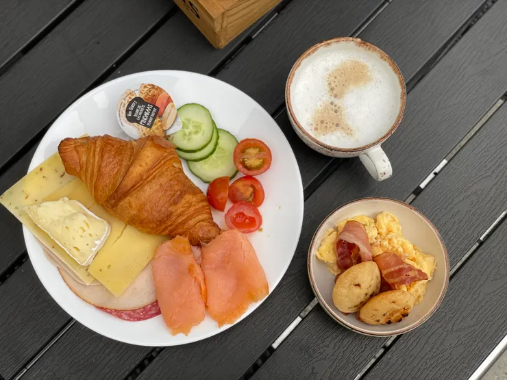 自助式早餐供應麵包、水果、起司、火腿、咖啡