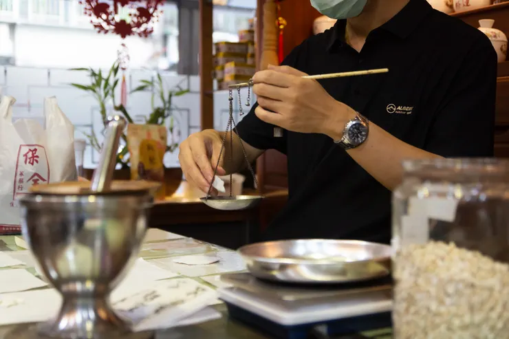 老闆熟練地秤取藥材,仔細地一一分裝。