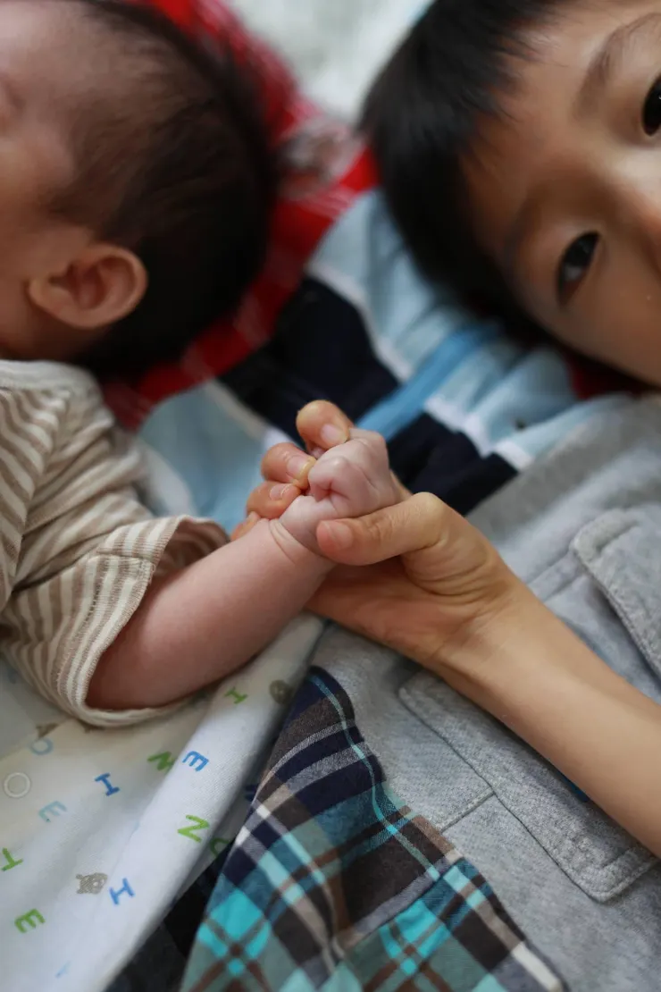 爸爸視角拍到祐握著弟弟的手（抓握不容易的腦麻兒）。