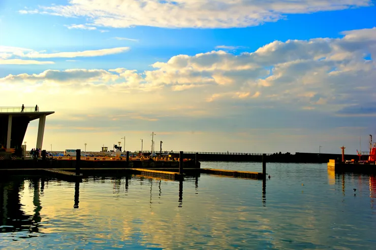 【賞嘆劉棟拚布畫搞怪沙灘夕照中！離開美術館，前往沙灘看看裝置藝術途中回顧，左側可見觀景伸展台。】