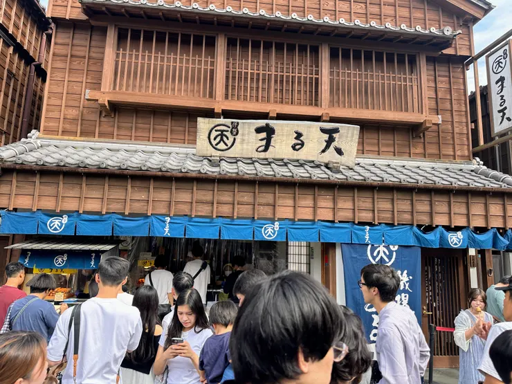 知名海鮮炸物連鎖品牌丸天，吸引許多遊客駐足購買炸魚餅品嘗