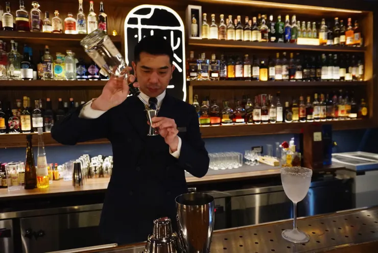 Shawn 正專注於將酒注入 Jigger