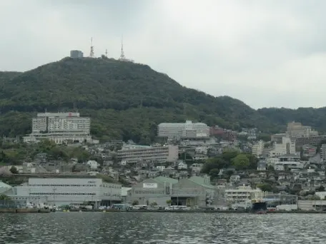 坐在船內，遠望矗立於長崎海灣上的山景及半山腰間的建築