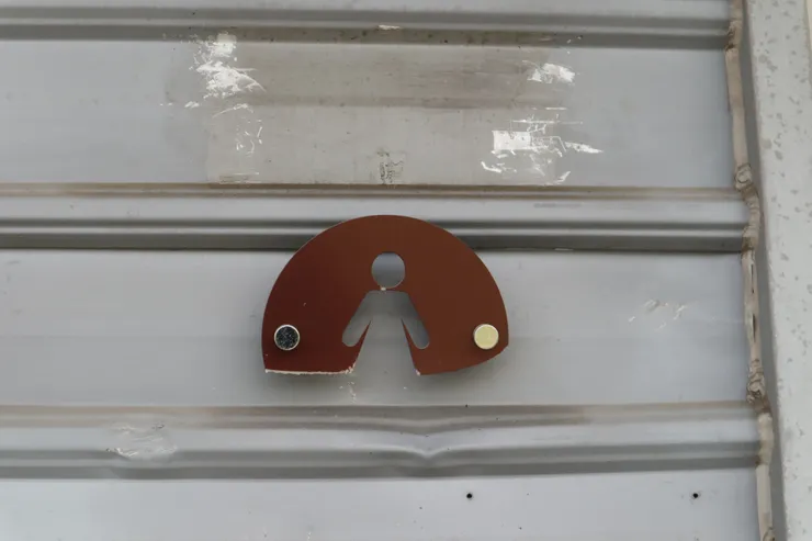 被砸到下半部已經斷掉的女廁標示，牆上也有凹痕