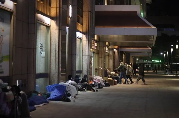 夜晚的臺北車站外聚集了許多街友 (圖片來源：聯合新聞網)