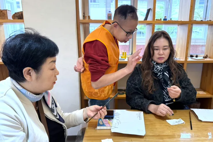 （圖說：雖然語言不同，但服務使用者(中)與韓國貴賓仍透過簡單英文，加上生動的比手畫腳，彼此順利交流。）