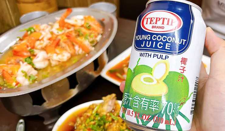手持 Teptip 泰國原裝椰子水（含果肉），背景為夏天小館的泰式檸檬鮮蝦。