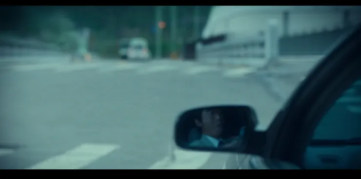 趙萊赫待在車禍遠處，好整以暇著觀察車禍「測試」的結果。( Source : Disney + )