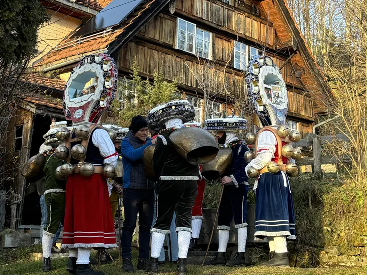 受到新年祝福的家人提供飲料及吸管,讓除夕老人透過面具上的嘴巴開口暢飲。(攝影/漢斯魯艾迪.丁)