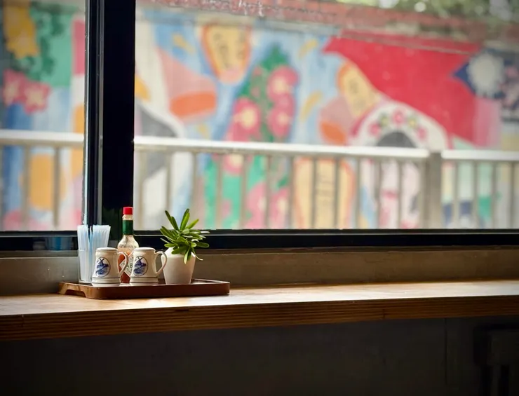 咖啡館緊鄰新興國中彩繪圍牆，剛好形成窗外繽紛風景