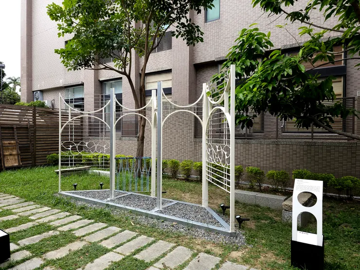 〈花舞三重奏〉相對完整地保留建築中的鐵窗花原貌，透過與新鐵件重新焊成可以穿梭其中的門與路徑。