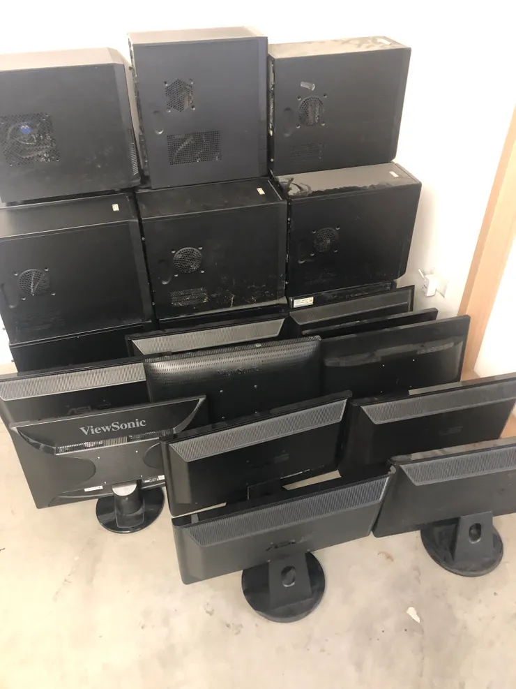 拆完硬碟的機器堆在牆角，還有一堆螢幕。