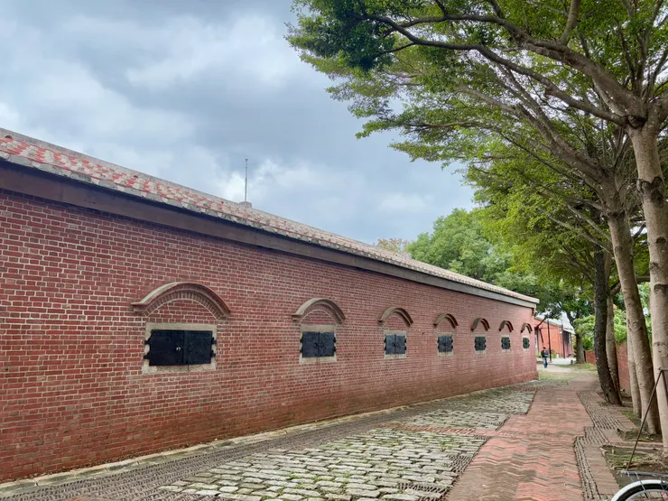 素雅的小葉欖仁襯托著百年紅磚倉庫，靜靜的訴說著歷史的軌跡