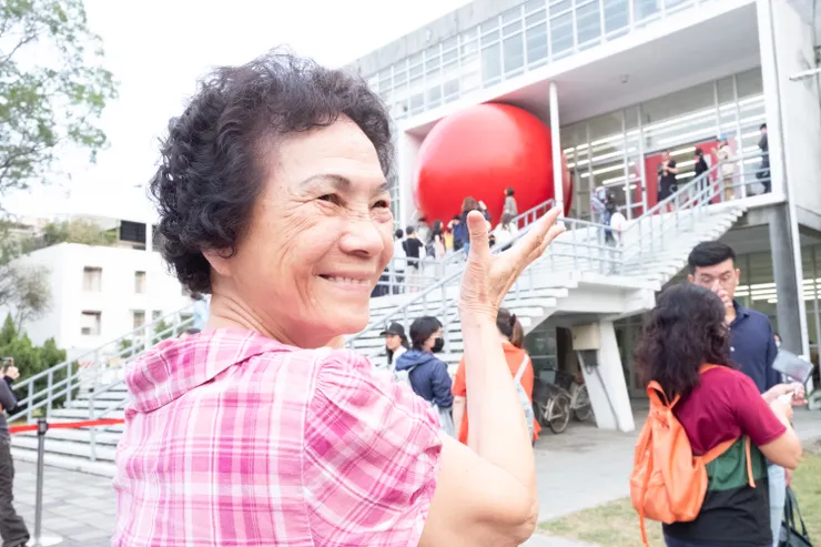 〔圖八〕在地民眾梁小姐手捧紅球借位合影