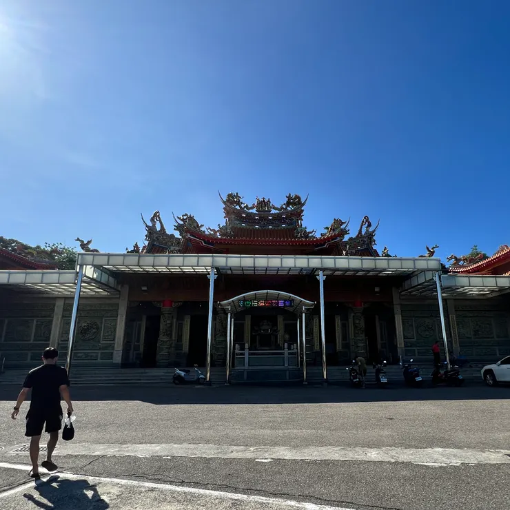 廟前香煙被風帶起，燈籠在半空中輕晃。