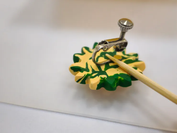 💎安裝耳環配件  作品冷卻後，拿耳夾背面沾取少量瞬間膠，黏在花朵的背面，用牙籤按壓10秒中固定。  可塗一層透明ＵＶ膠，提升光澤與耐用度。